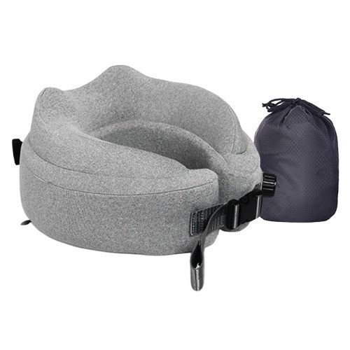 Traveller using a self-inflating neck pillow at an airport terminal, deflated pillow easily stored in carry-on.
