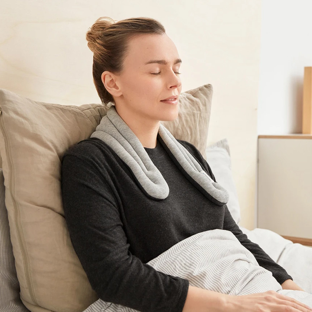 Woman resting on on bed with her neck wrap